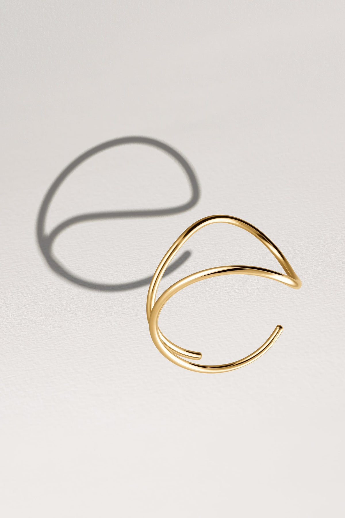 Primo piano della chiusura su Bracciale a Polsino Outline Lettera E in filo d'oro giallo laminato 14k