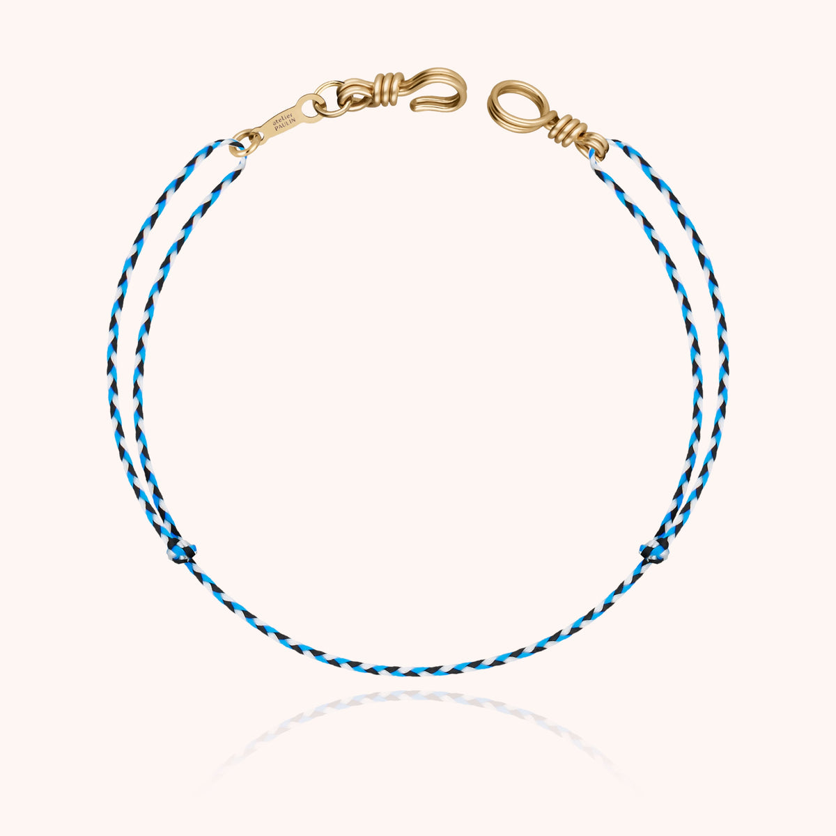 Overall view of the personalized Cord Bracelet Mini Attache moi with its gold signature tag