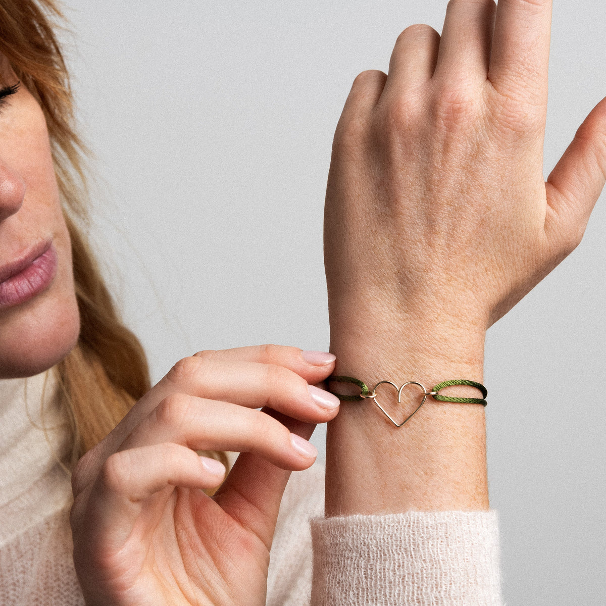 Bracciale Cordino Cuore in filo d'oro giallo laminato 14k, portato al polso
