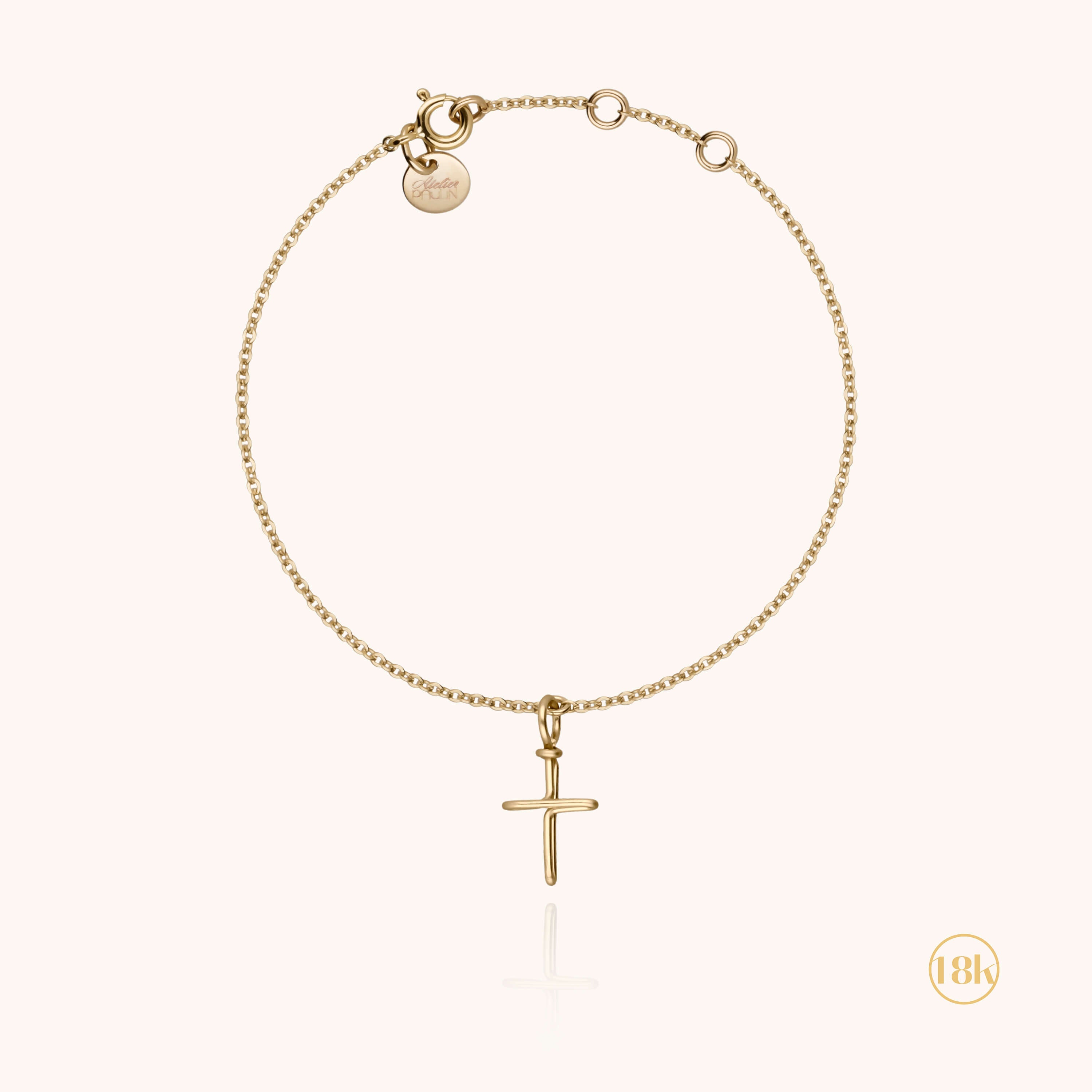 Bracelet avec croix or porté au poignet d'un enfant, fermoir doré visible