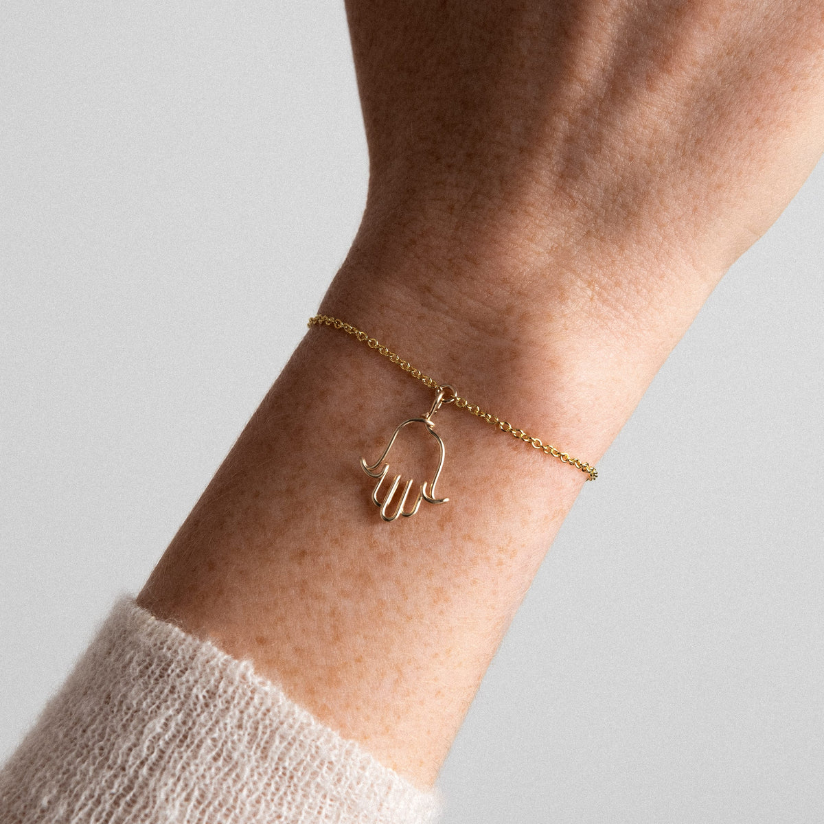 Dettaglio del charm mano di Fatma in filo d'oro giallo 18kt sulla catena Richelieu
