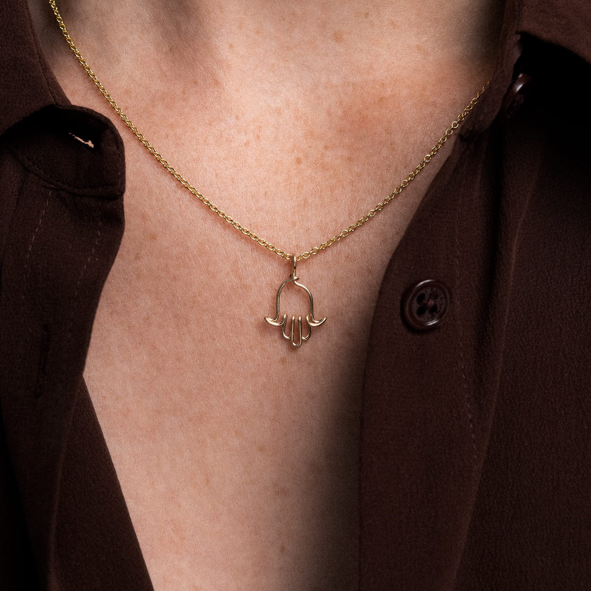 Dettaglio del charm mano di Fatma modellato a mano in filo d'oro giallo laminato 14k