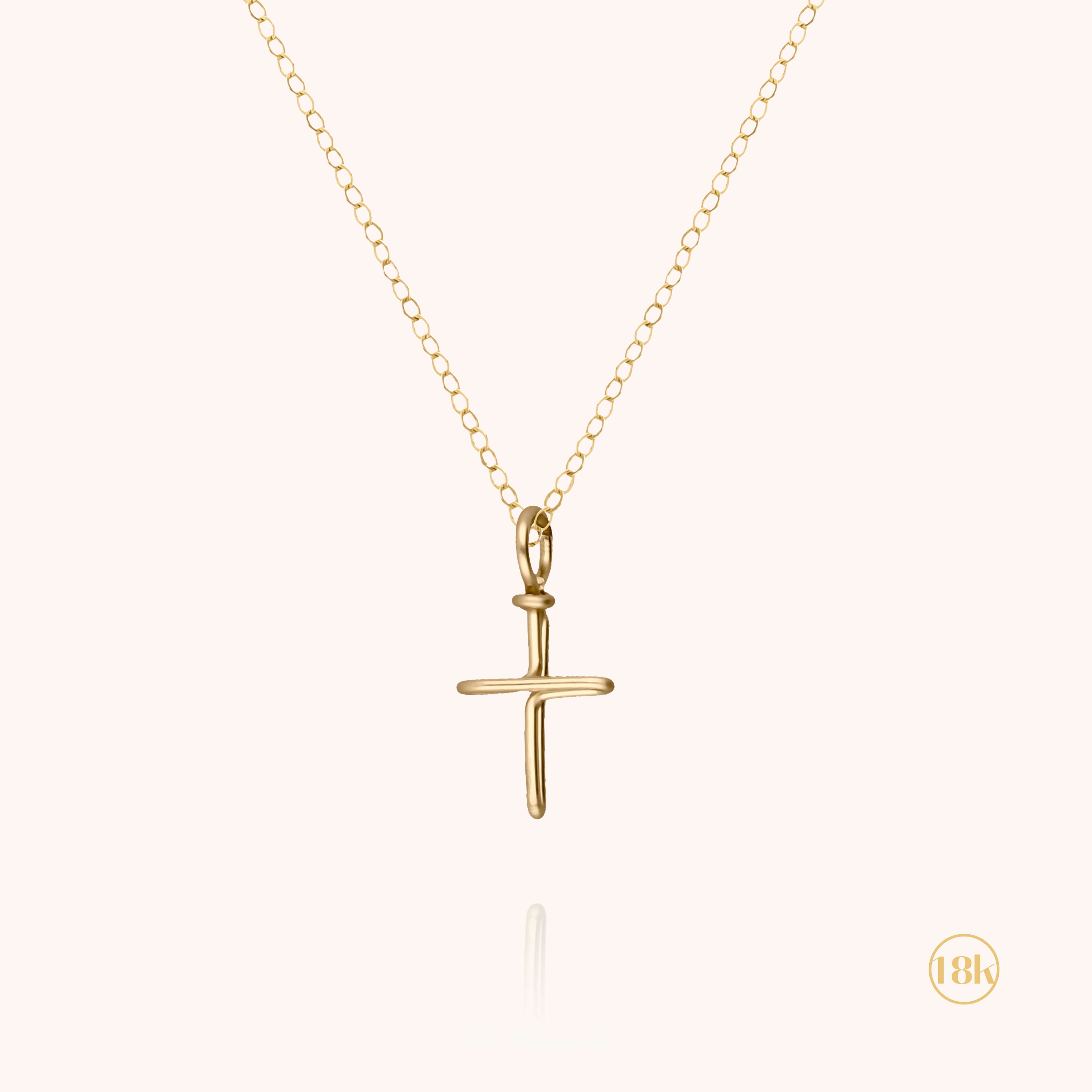 Collier charms croix en or jaune 750 pour enfant sur fond blanc