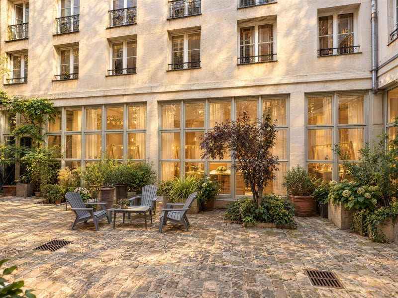 Les grandes baies vitrées de l’atelier Atelier Paulin, face à la cour pavée du 8 bis rue de Braque à Paris