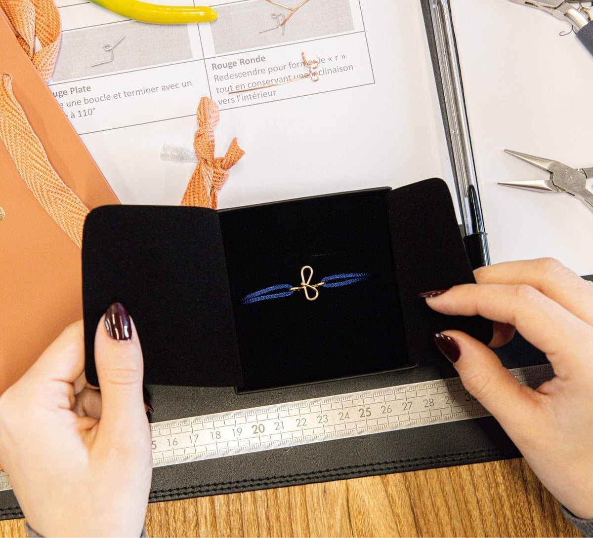 À la fin de l’atelier Au fil de l’or : le bracelet initiale façonné à la main, sur son cordon bleu, dans son écrin