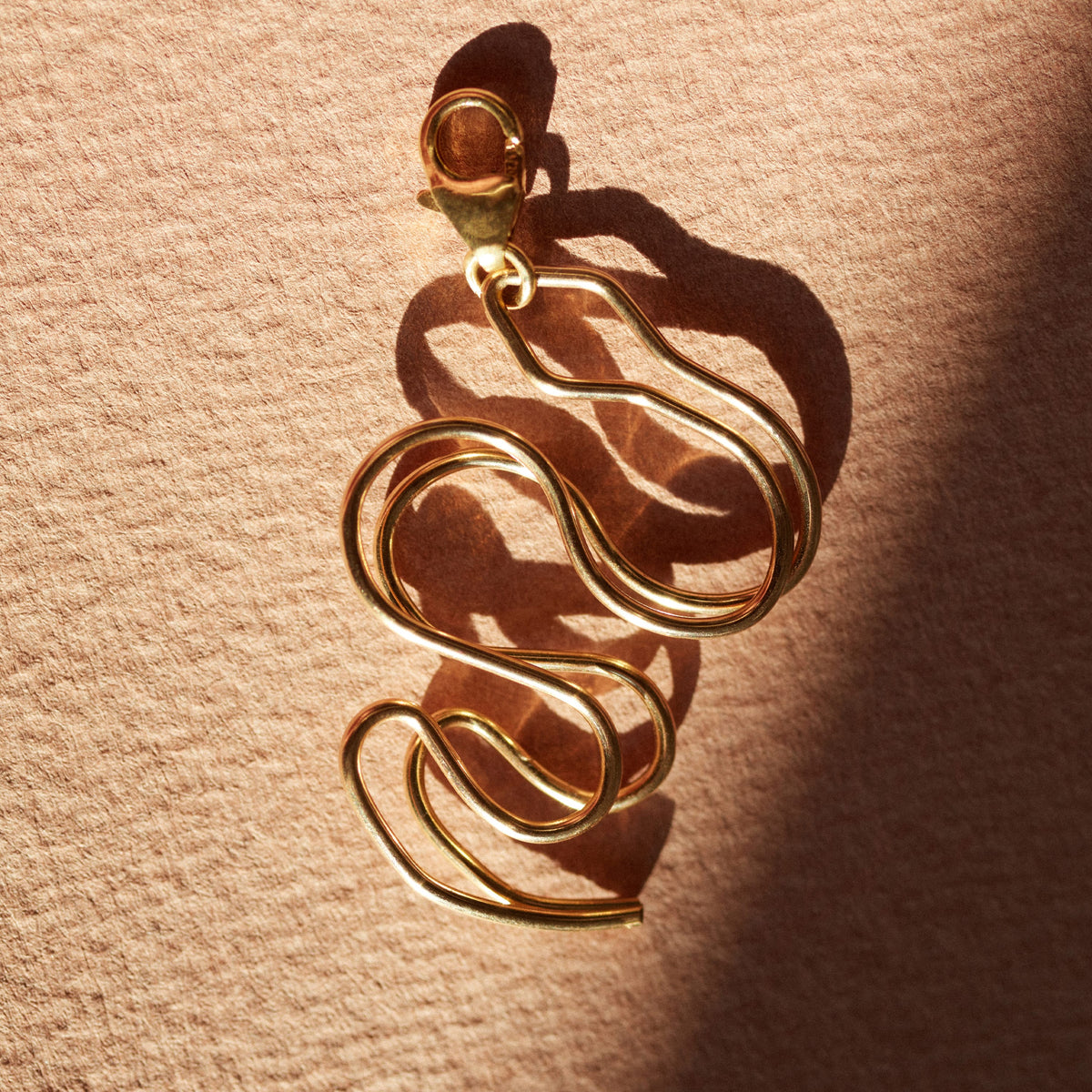 Dettaglio della modellatura a mano su Big Locket Charms Serpente in filo d'oro laminato 14k