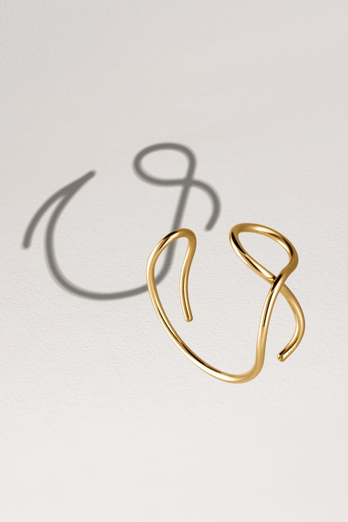 Primo piano del filo d'oro giallo laminato 14k su Bracciale a Polsino Outline Lettera V