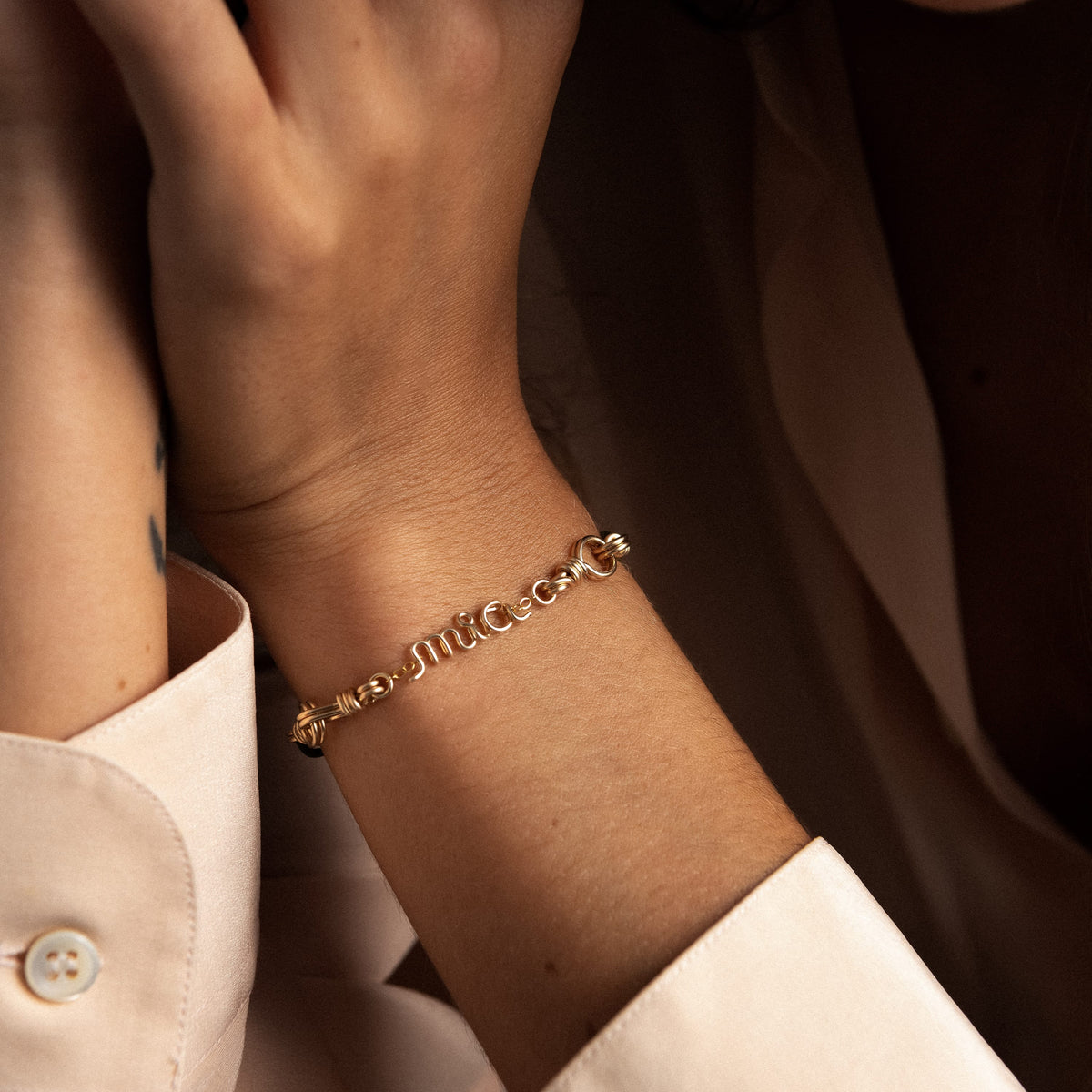 Detail des personalisierten, von Hand geformten Wortes aus gelbem Golddraht (Goldfilled)