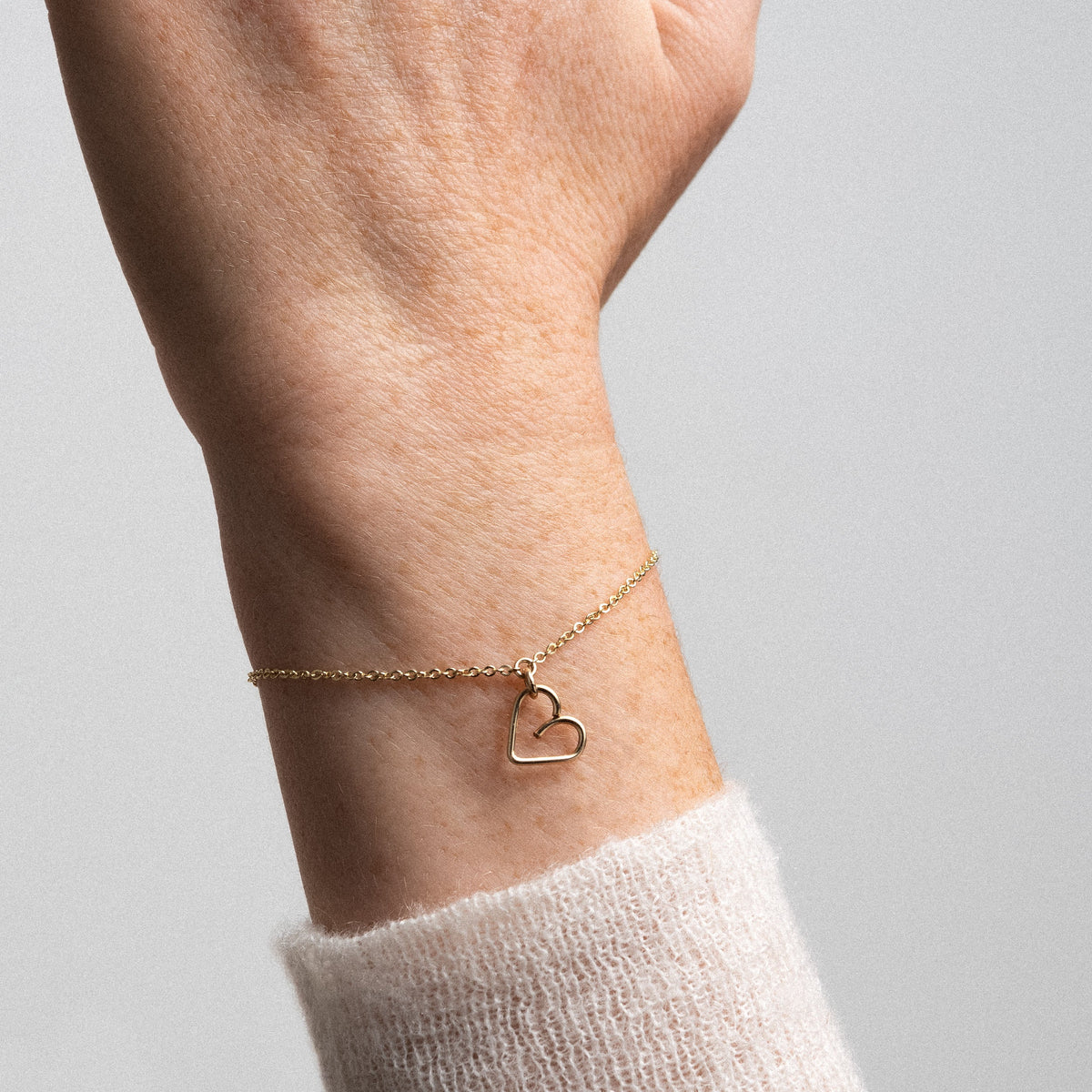 Bracciale Lucky One Charms Cuore in filo d'oro giallo laminato 14k, portato al polso