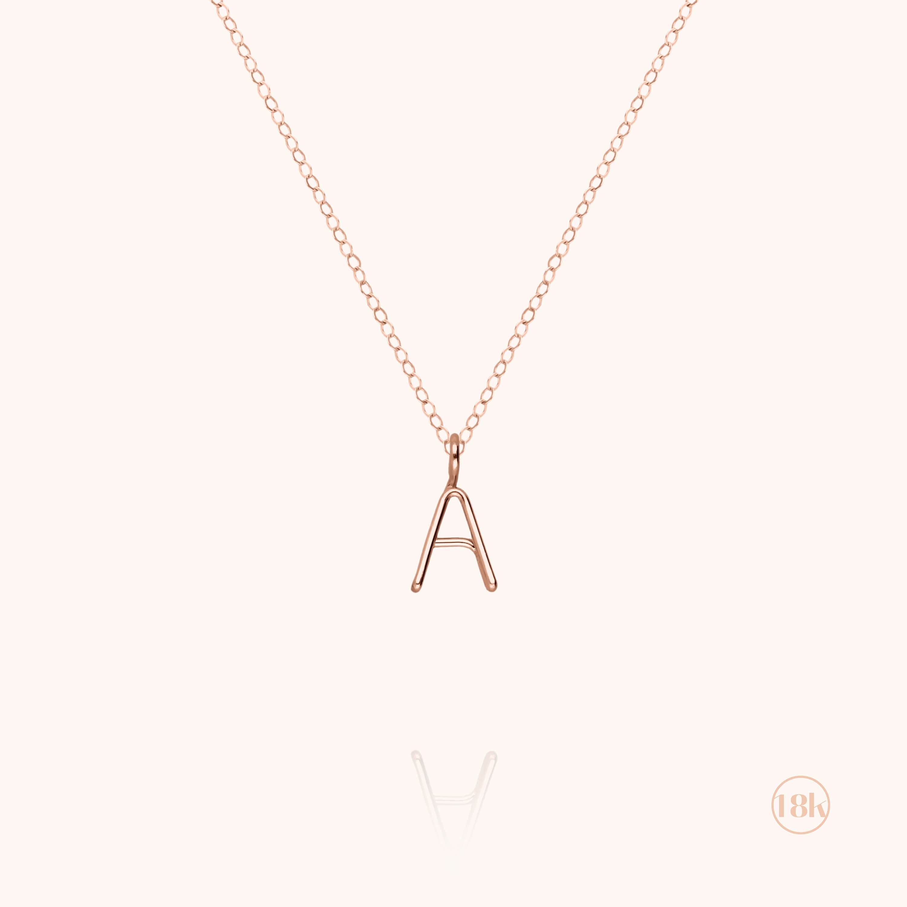 Collier Capital Initiale porté au cou — or rose 18K livraison soigneuse garantie