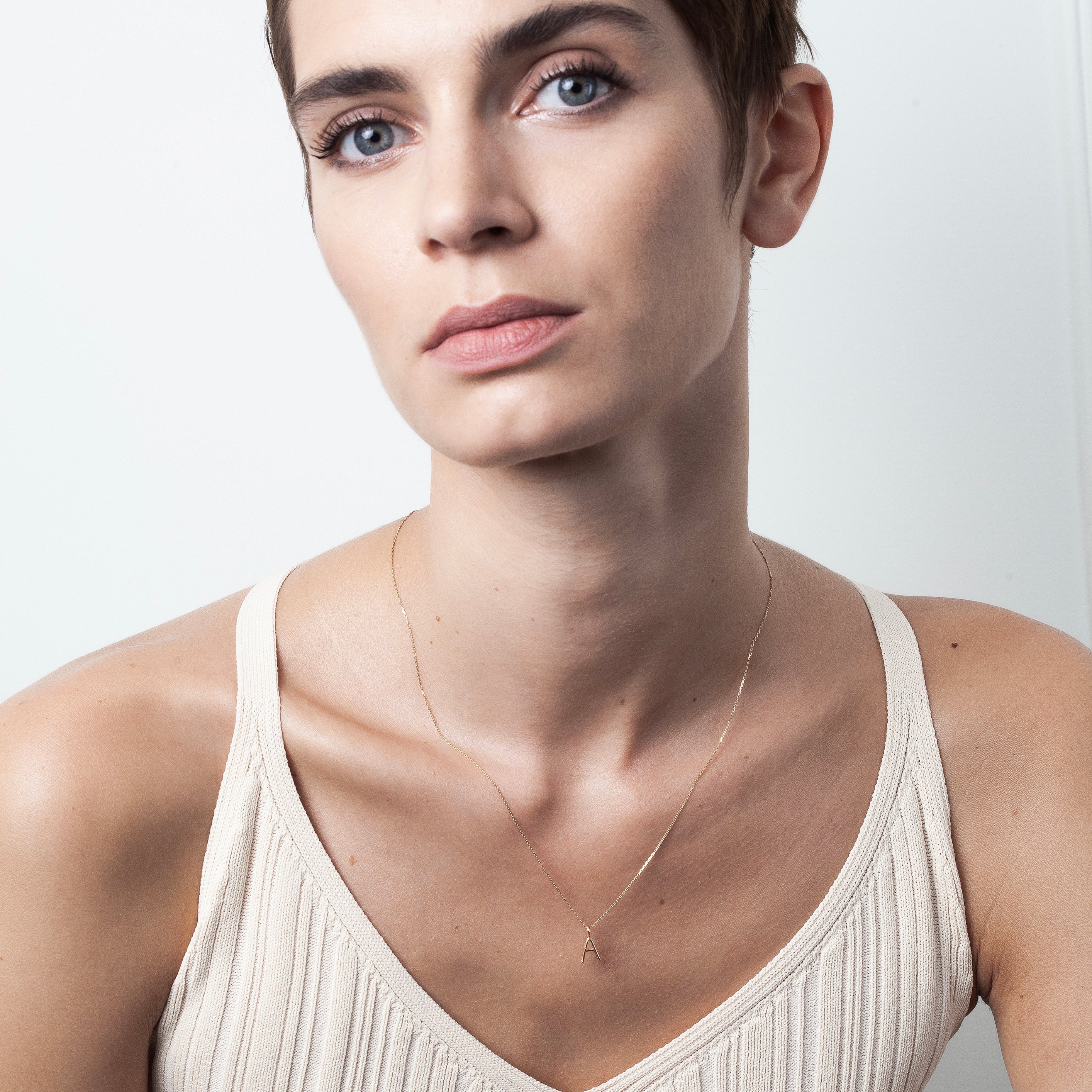 Collier Capital Initiale — détail façonnage à la main, or jaune 18K