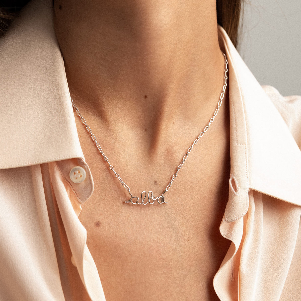 Dettaglio della modellatura a mano delle lettere in filo d'argento sterling 925