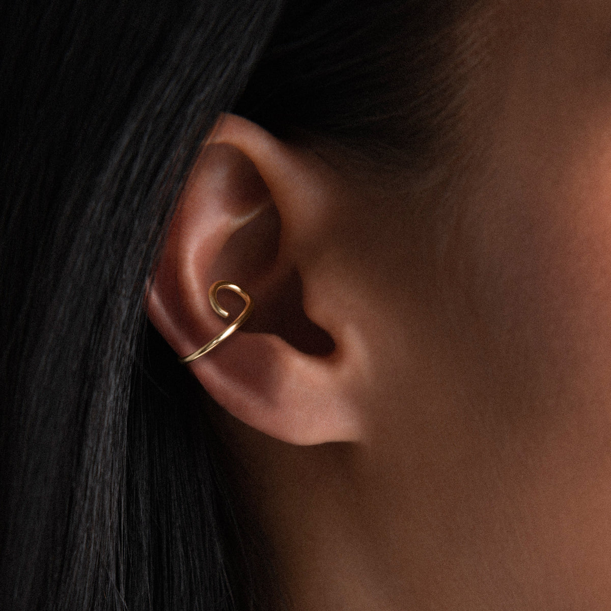 Ear Cuff Outline Lettera O in filo d'oro giallo laminato 14k, portato all'orecchio