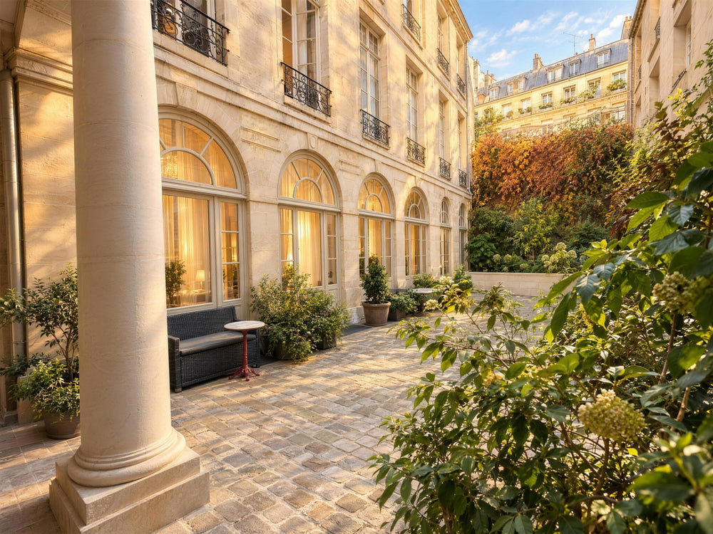Sous le porche du 8 bis rue de Braque : une colonne de pierre et la cour pavée et plantée où se trouve l’atelier Atelier Paulin